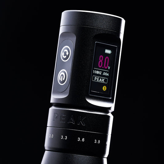Close-up of a Peak tattoo machine’s voltage display and stroke adjustment markings.