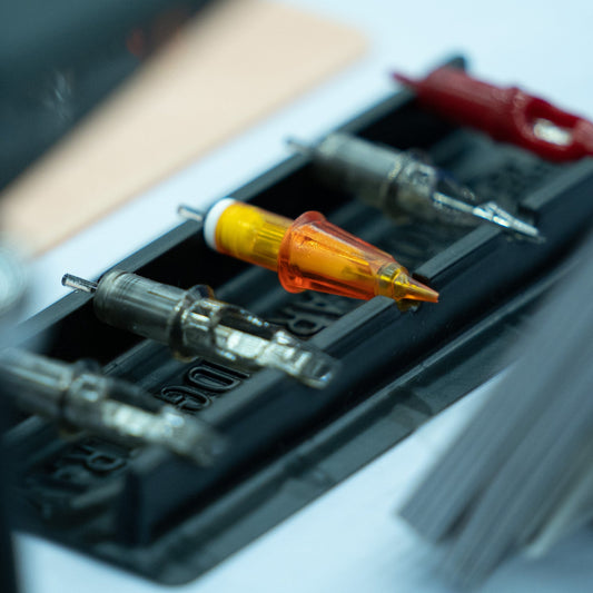 Tattoo needle cartridges arranged on a black holder.