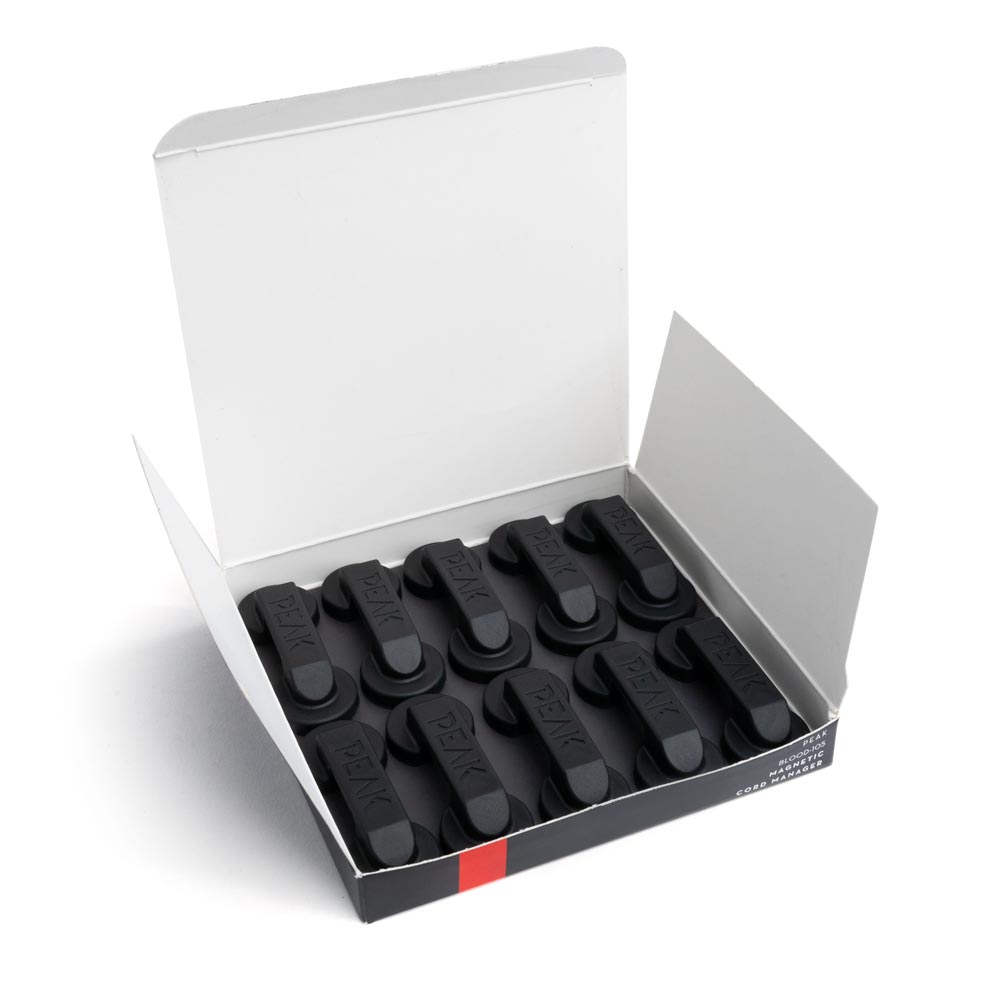Open box of ten magnetic cord managers on white background