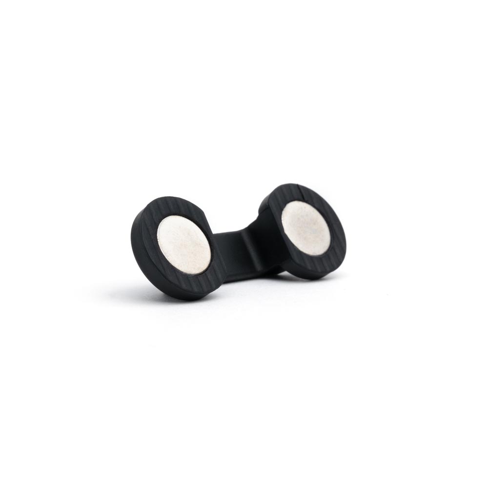 Bottom magnets on underside of cord manager on white background