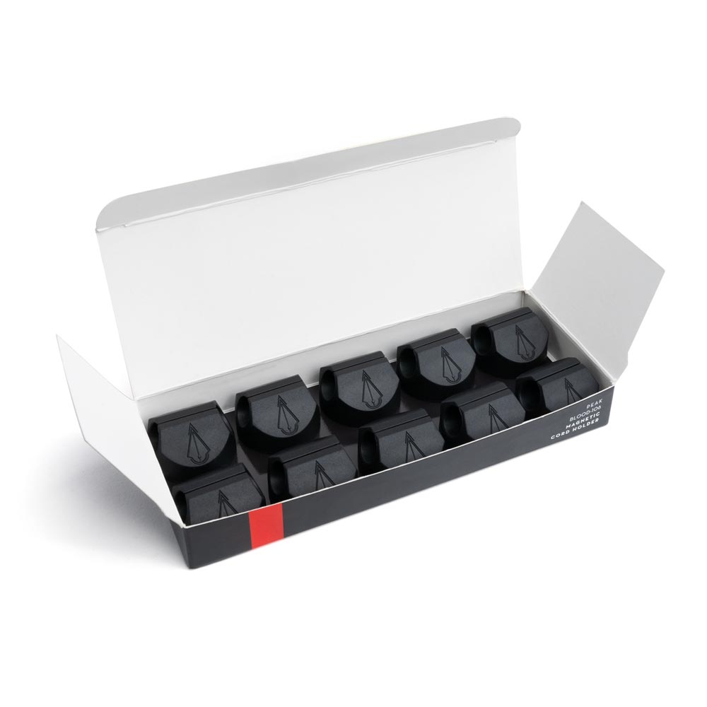 Open box of ten Magnetic Cord Holders on white background
