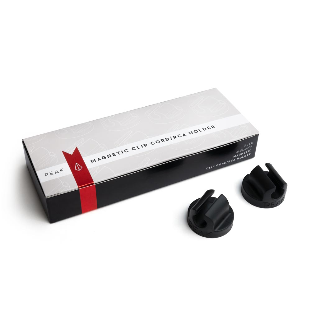 Box of Magnetic Clip Cord/RCA Holders with two holders out of box on white background, full size