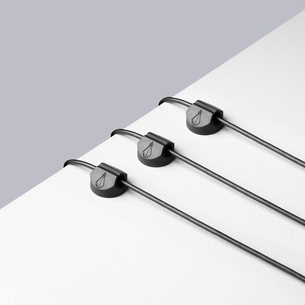 Example of three cord holders on workstation surface holding wires